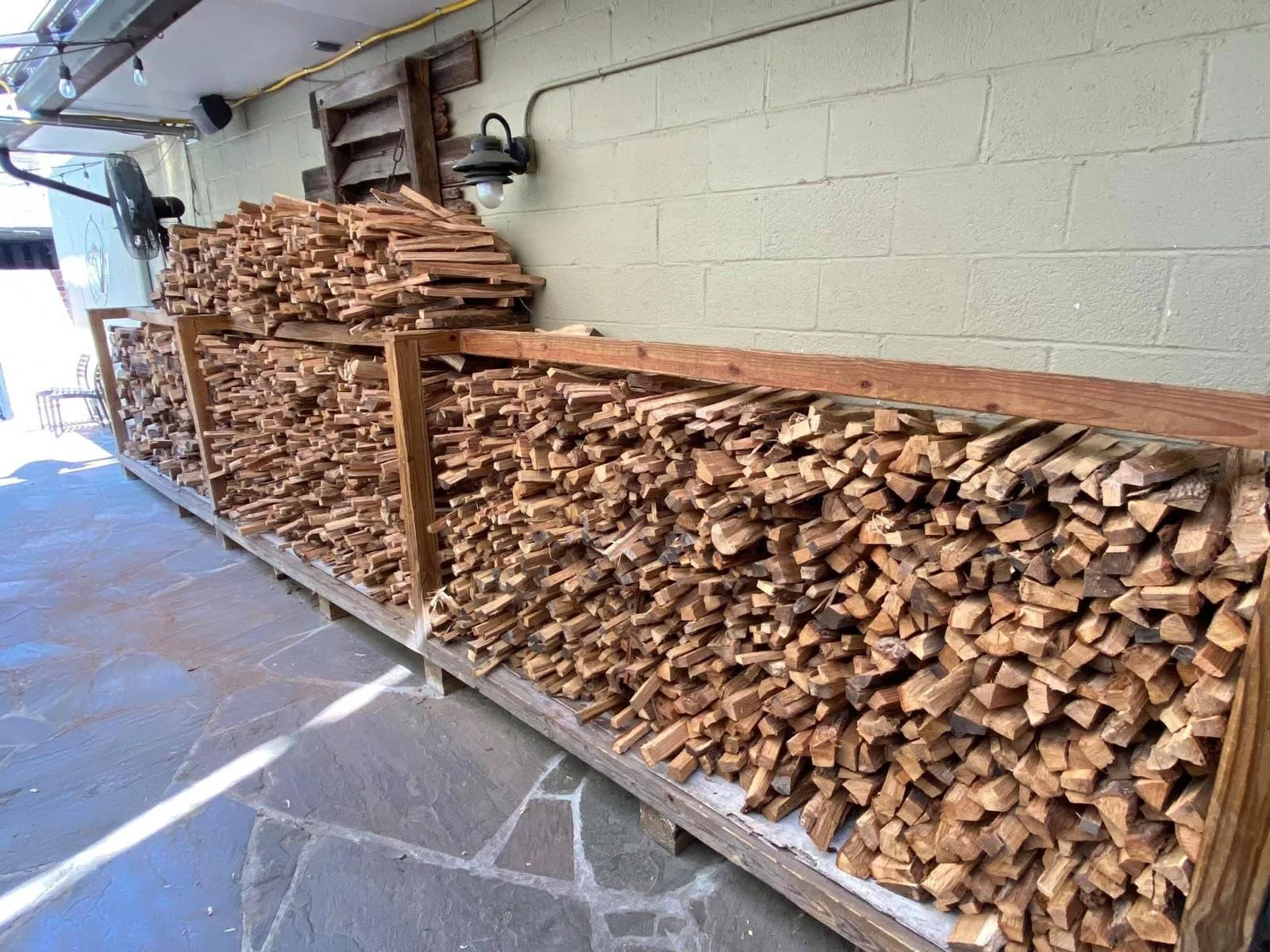 Split firewood arranged in long covered wooden storage racks